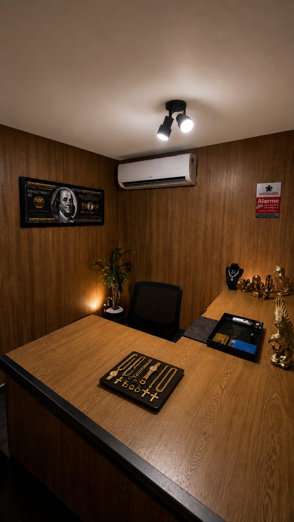 Sala de avaliação da Compro Ouro Bangu, com mesa para análise de joias, ambiente reservado e alarme com ligação à polícia